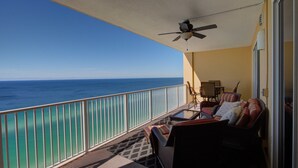 Balkon med havudsigt, loftventilator og siddeområde med sofa og stole.
