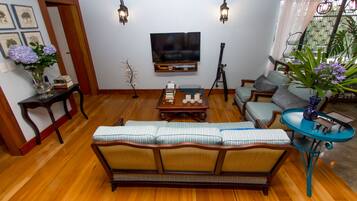 A living room with a sofa, a coffee table, a TV, and a lamp.