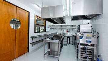 A modern kitchen with stainless steel appliances, a wooden door, and a window.