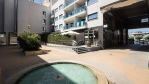 A courtyard with a swimming pool, a staircase leading to a building entrance, and a small garden area.
