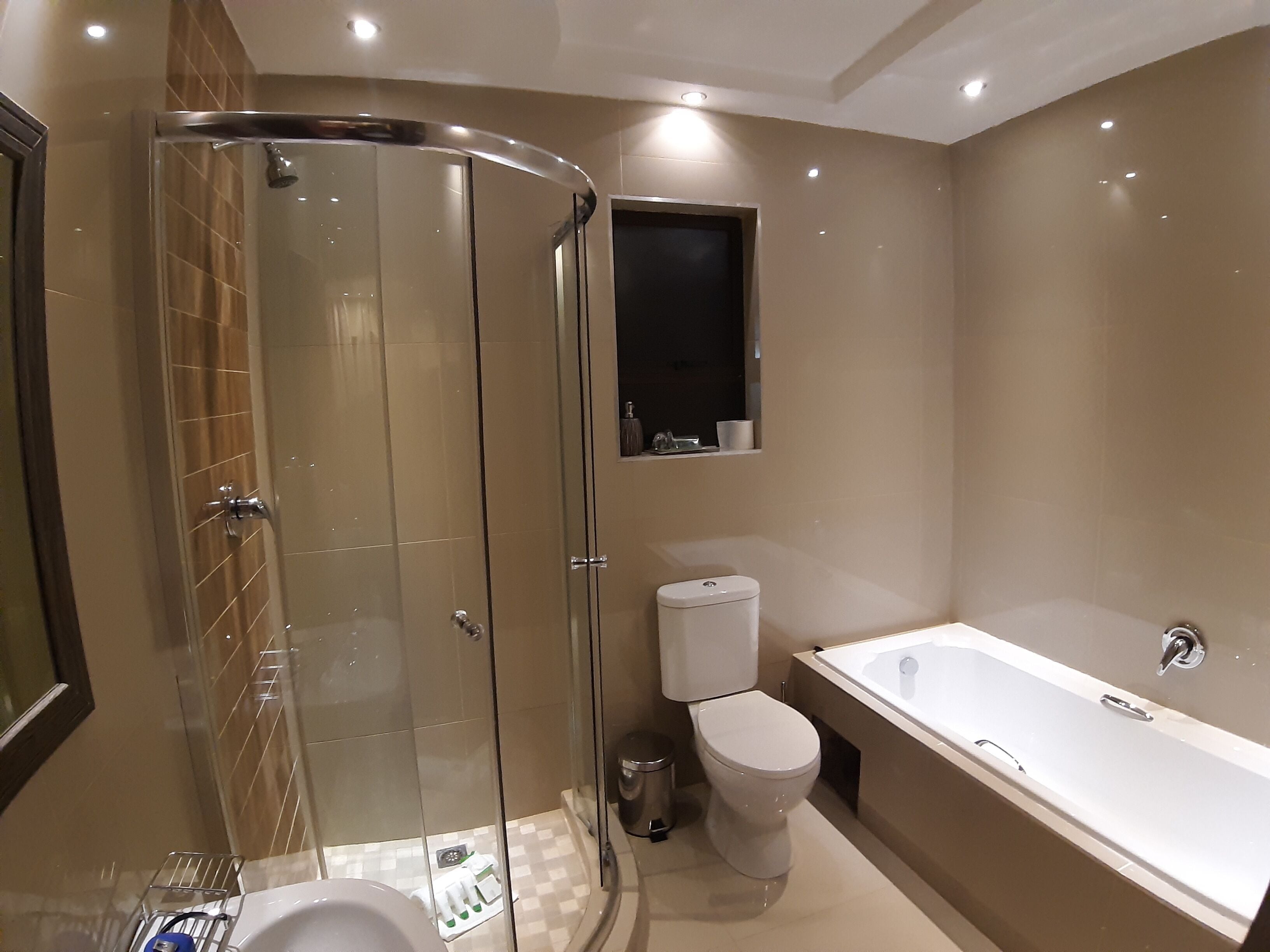 Un baño moderno con cabina de ducha de vidrio, inodoro y bañera.