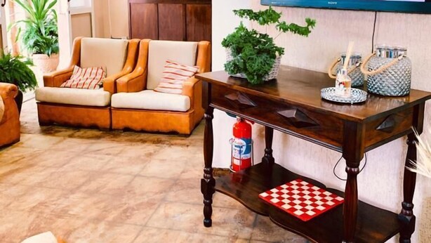 Een woonkamer met een bank, een salontafel en een televisie aan de muur.