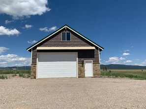 Un bâtiment d’un seul étage, doté d’un garage, d’une petite porte et d’une fenêtre.