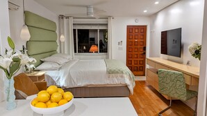 Een moderne slaapkamer met een bed, nachtkastje, lamp en een schaal met citroenen.