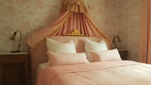 A bedroom with a bed, a nightstand, and a lamp.