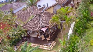 A house with a tiled roof, a covered porch, and a swimming pool. - Planeta Banana B&B (Paraty)