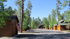A row of log cabins with a clear sky and trees in the background. - Pinetop Country Club Hand Haven (Pinetop)