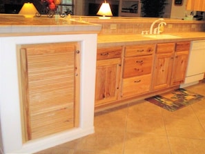 A kitchen with wooden cabinets, a sink, and a countertop.
