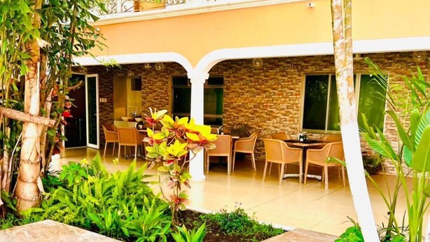 A courtyard with a pool, dining area, and a stone wall. - Hotel Los Cedros Uayamon (Uayamon)