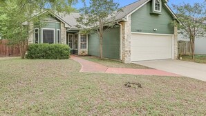 A single-story house with a garage, a small front yard, and a pathway leading to the entrance. - Great Home in Austin's Wells Branch Neighborhood! (Austin)