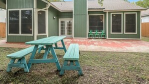 A house with a green exterior, a covered patio, and a picnic table. - Great Home in Austin's Wells Branch Neighborhood! (Austin)