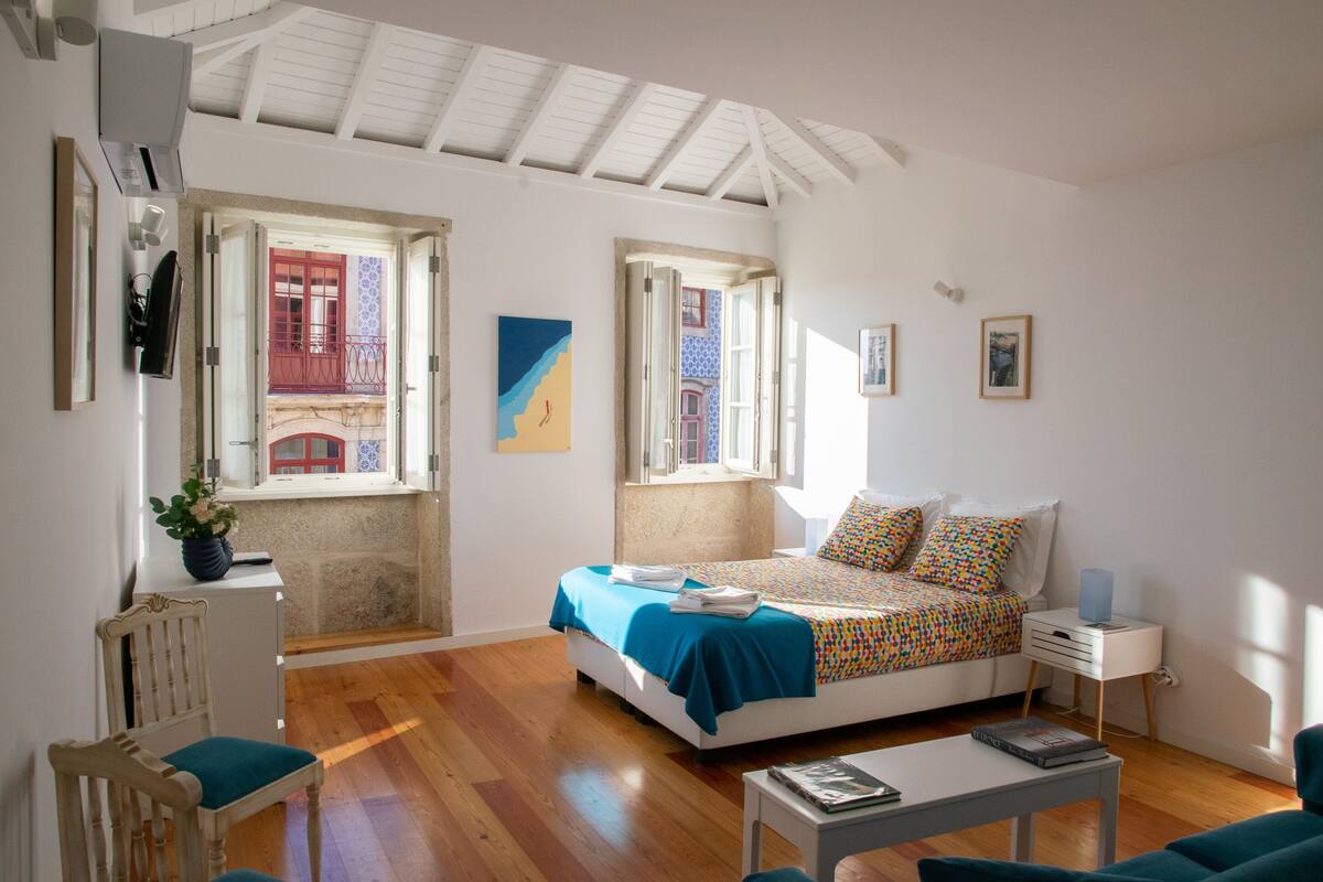 A bedroom with a bed, bedside table, and a window.