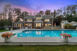 A two-story house with a swimming pool, a balcony, and a patio area. - Sag Harbor Luxury Estate with Pool, Spa & Gym on 3 Private Acres (East Hampton)