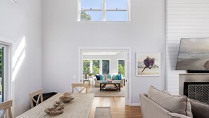 Una habitación amplia con una mesa de comedor de madera, un sofá y una chimenea.