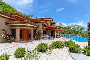 Una casa moderna con piscina, patio y jardín.
