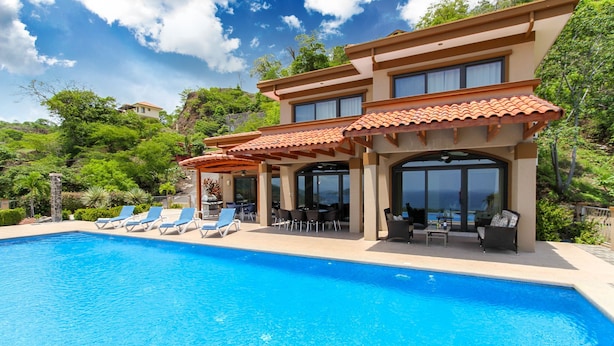 A poolside area with lounge chairs and a covered patio. - Casa Antonelli (Sardinal)