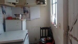 Una cocina compacta con electrodomésticos básicos, una ventana con vistas y un pequeño comedor.