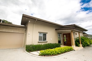 A modern two-story house with a garage, a front porch, and a well-maintained garden. - Casa Circo (Sardinal)