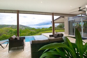 A modern outdoor lounge area with a pool, seating, and a view of the landscape. - Casa Circo (Sardinal)