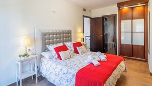 Une chambre bien rangée, avec un lit, des tables de chevet et une armoire.