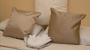 Un lit avec des oreillers de couleur beige et une serviette blanche.