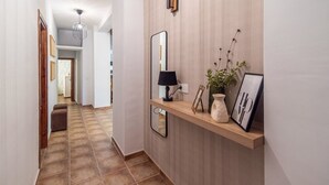 A hallway with a wooden console table holding a lamp, framed pictures, and a vase. - Villa Las Gayumbas Villanueva de la Concepción by Ruralidays (Málaga)