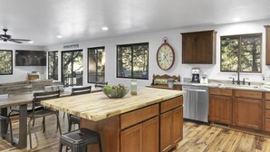 Una cocina moderna con armarios de madera, una isla central y un lavavajillas empotrado.