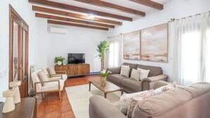 Un salon comprenant un canapé, une table basse, un téléviseur et une plante.