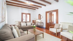 Un salon comprenant un canapé, des fauteuils, une table basse et une cheminée.