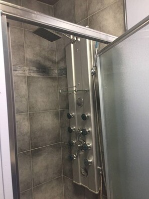 Een bad/douchecombinatie, een haardroger, handdoeken, zeep