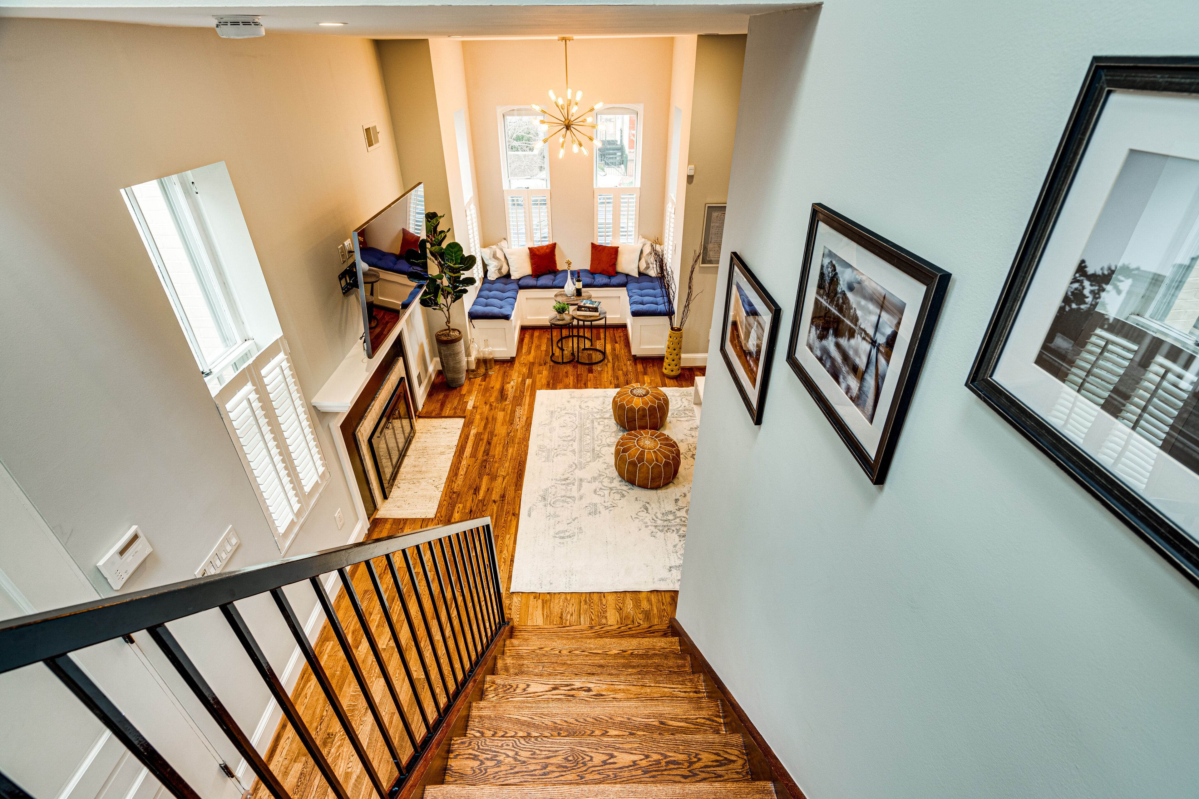 A staircase leading to a living area with a sofa set, a coffee table, and a chandelier.