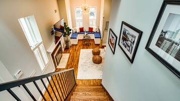 A staircase leading to a living area with a sofa set, a coffee table, and a chandelier.