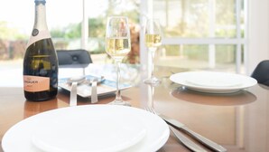 A table set for two with a bottle of wine, two glasses, and cutlery.