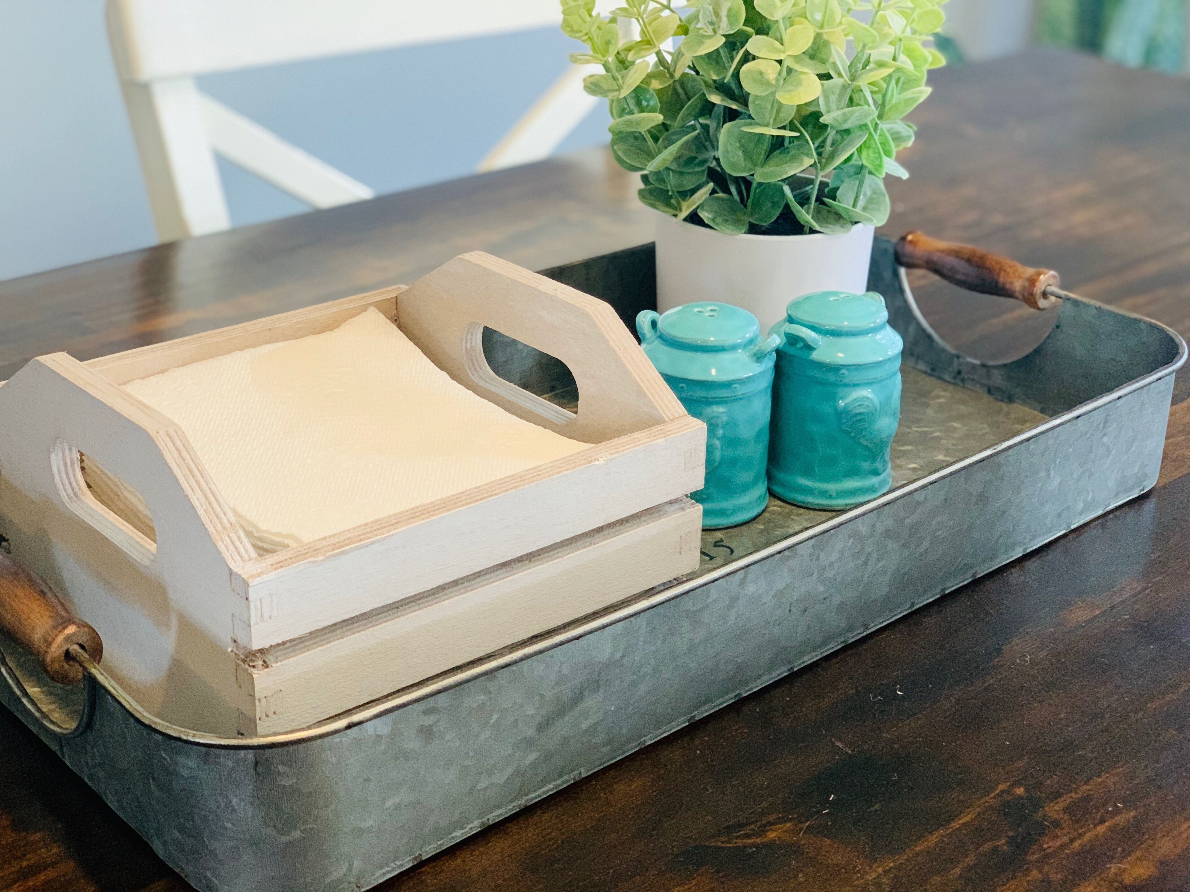 A tray with a wooden box, a potted plant, and two ceramic containers.