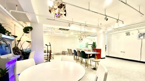 A modern conference room with a round table, white chairs, and a large screen. - Namsan Forest Myeongdong Station (Seoul)