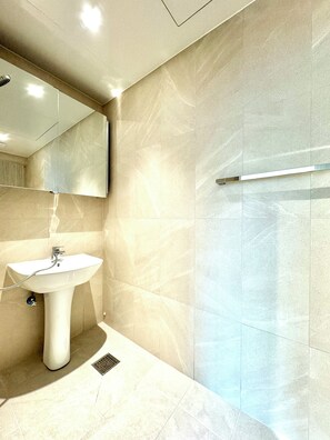 Superior vierpersoonskamer | Badkamer | Een douche, een haardroger, pantoffels, handdoeken