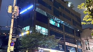 A multi-story building with illuminated signage, including "GRANDFIELD" and "YMNSAN FOREST." - Namsan Forest Myeongdong Station (Seoul)