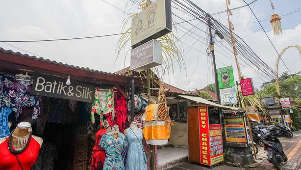 A street with various shops, including a store named 'Batik & Silk' with mannequins displaying colorful dresses. - Padi-Padi Hostel & Bar (Ubud)