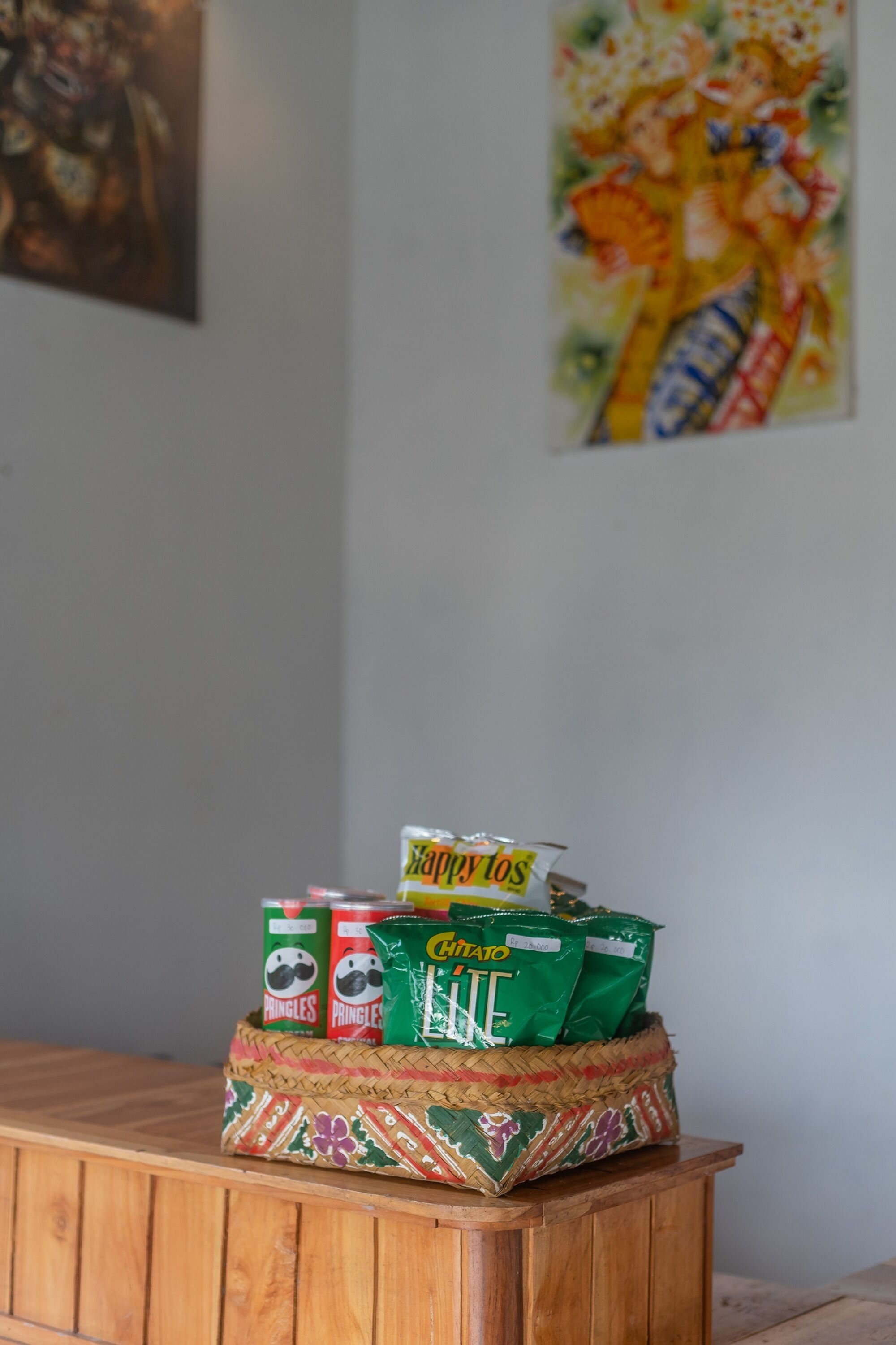 Ein Holzkabinent mit einem gewebten Korb, der mit Pringles und Chips gefüllt ist.