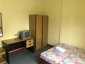 A small room with a bed, a desk with a television, and a wardrobe. - Hotel Pelita Terang (Batam)
