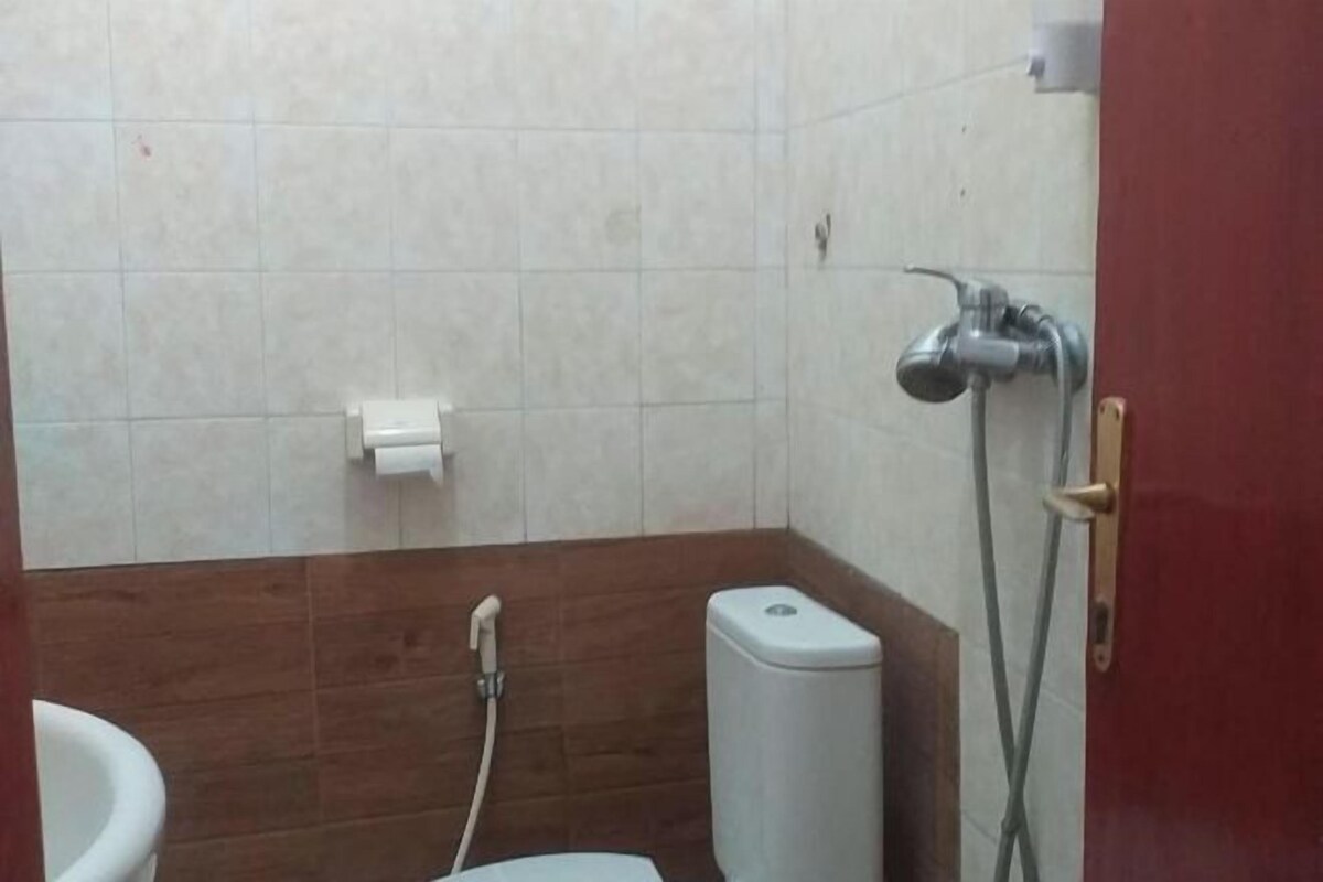 A bathroom with a toilet, a shower, and a sink.