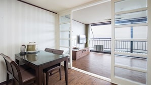 Une chambre d’hôtel avec un coin repas, une kitchenette, un balcon avec vue et une porte-fenêtre coulissante.