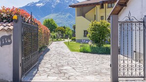 A stone pathway leading to a yellow building with a mountain backdrop.