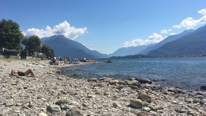 A rocky lake shore with people sunbathing and swimming. - Cosy apartment for 4 people with WIFI, TV, terrace and pets allowed (Vercana)