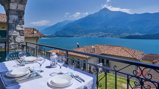 A table set for dining with a view of a lake and mountains. - Cosy apartment for 4 people with WIFI, TV, terrace and pets allowed (Vercana)