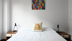 A hotel room with a bed, a pillow with text, a wall art piece, and bedside tables with lamps. - M150 - Marcelli, two-room apartment directly on the beach (Marcelli)