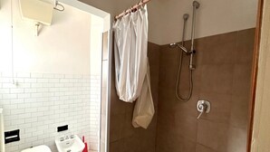 Ein Badezimmer mit Toilette, Bidet und Duschbereich.