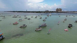 A marina with numerous boats and a distant view of a city skyline. - 5-Min Walk to Beach | Pool | Loaded Game Room | Near Shops & Outlets ✨ (Miramar Beach)