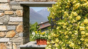 A stone wall with a window overlooking a mountain and a building. - Nice apartment in villa for 4 people with WIFI and terrace (Colico)