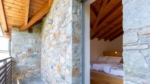 A stone-walled room with a wooden ceiling and a bed with white bedding. - Nice apartment in villa for 4 people with WIFI and terrace (Colico)